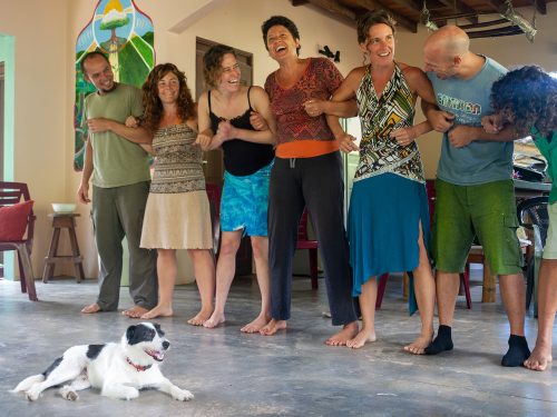 a line of laughing people with arms joined